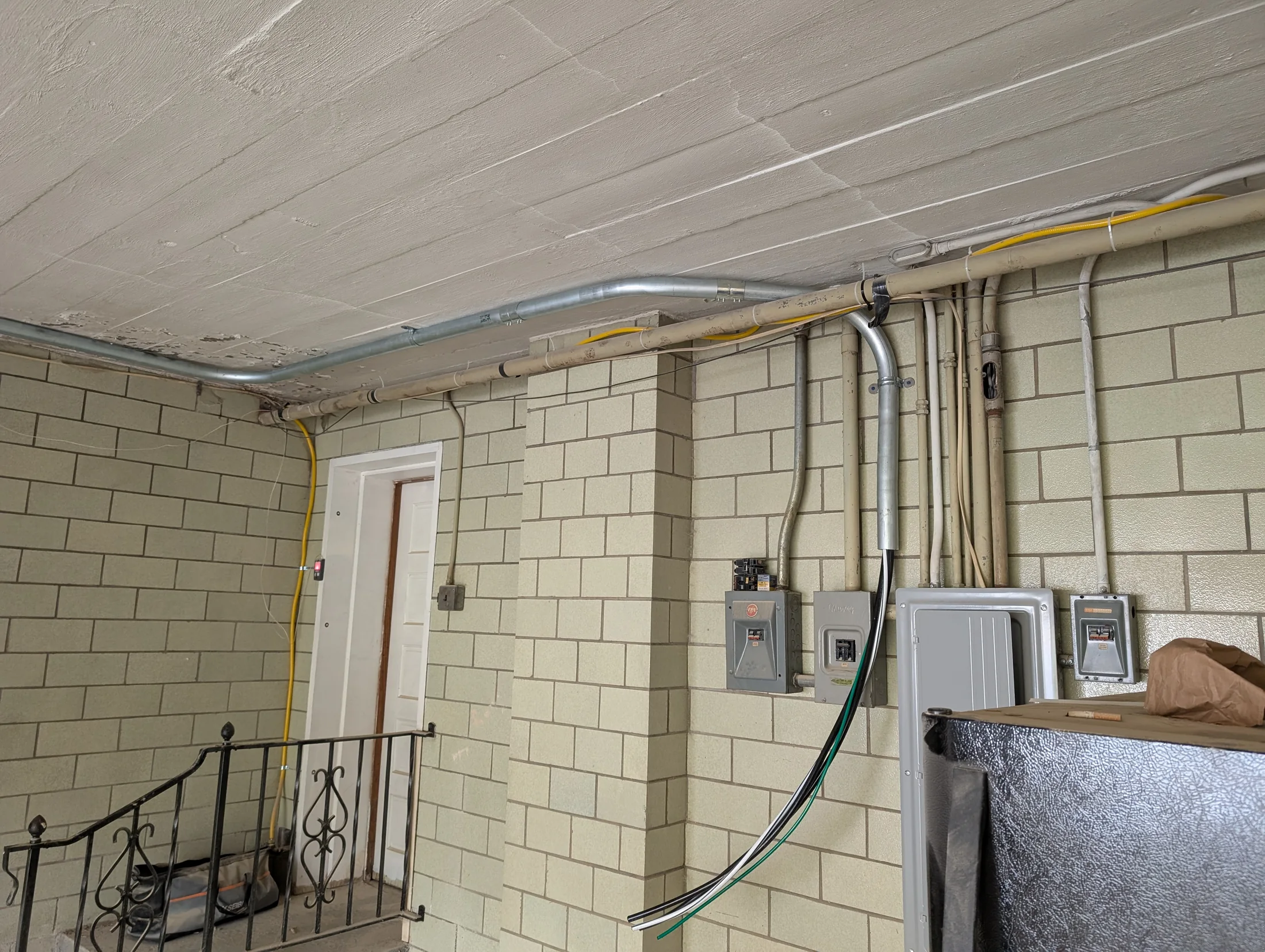 Electrical service conduit and panel installation on a masonry wall by State of the Arc Electric